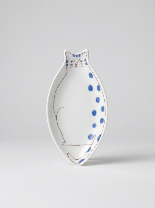Japanese cat-shaped kutani ceramic sauce plate with blue polka dots on a light gray background