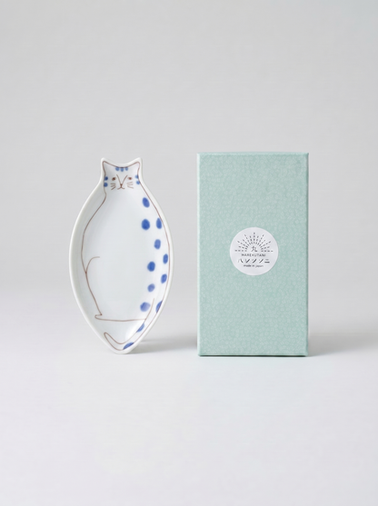 Cat-shaped ceramic dish with blue polka dots on a light gray background