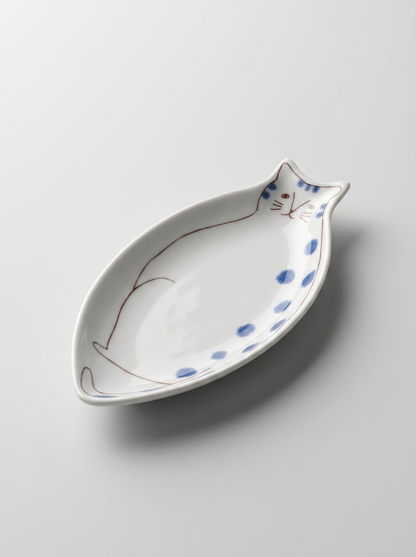 Cat-shaped ceramic dish with blue spots on a light gray background