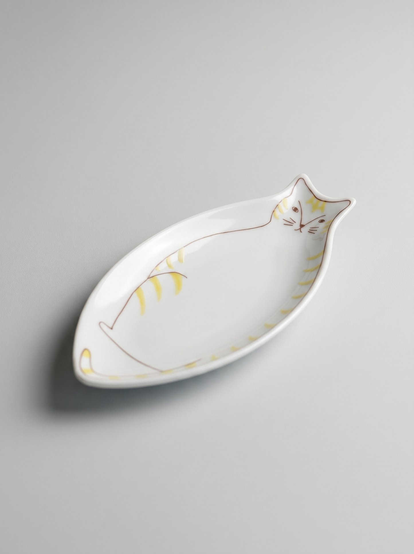 Cat-shaped ceramic dish on a gray background