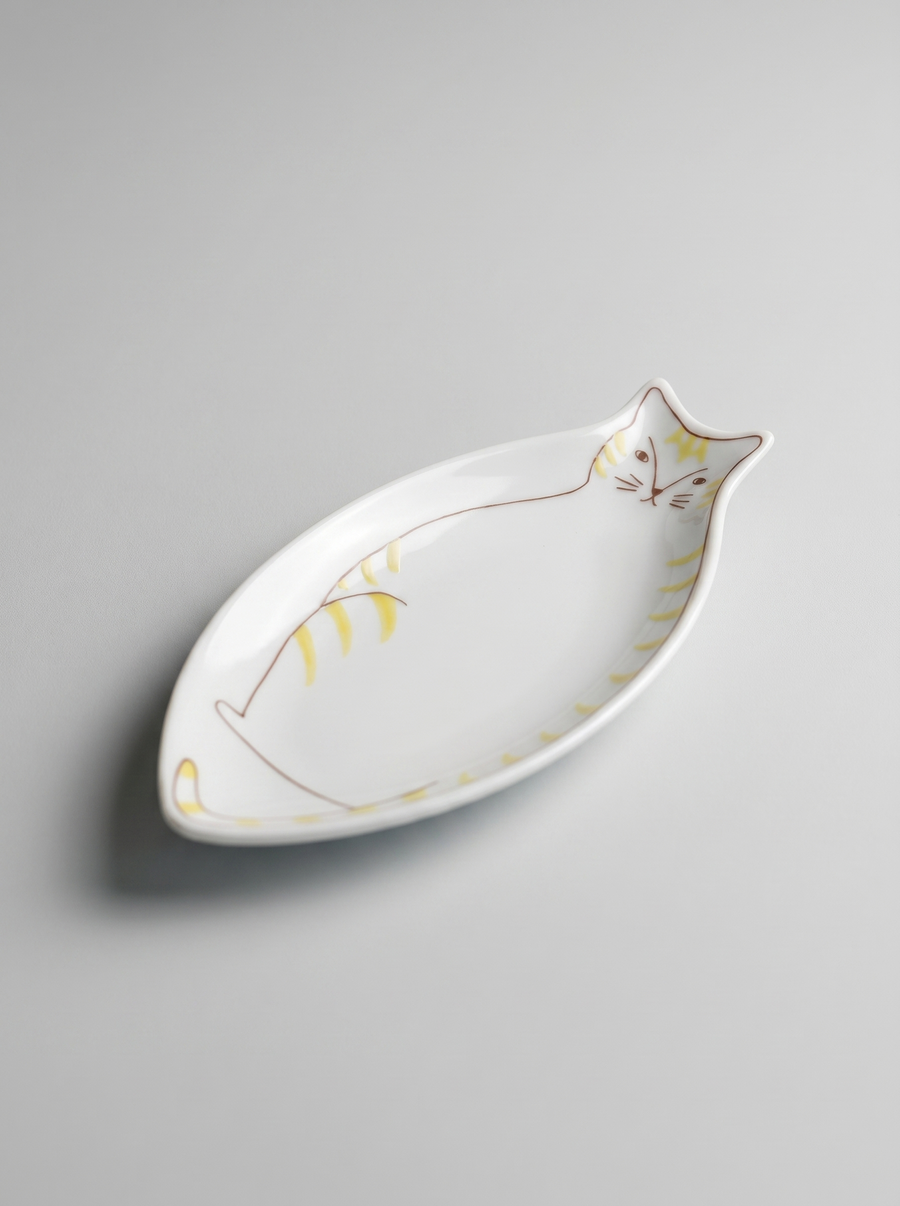 Cat-shaped ceramic dish on a gray background