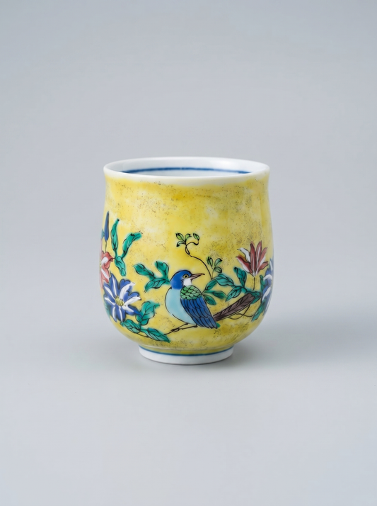 Japanese kutani yunomi ceramic cup with floral and bird design in yoshidaya style on a gray background